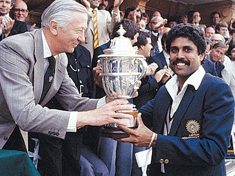 Indian captain holding Cricket World Cup 1983 trophy in hands.